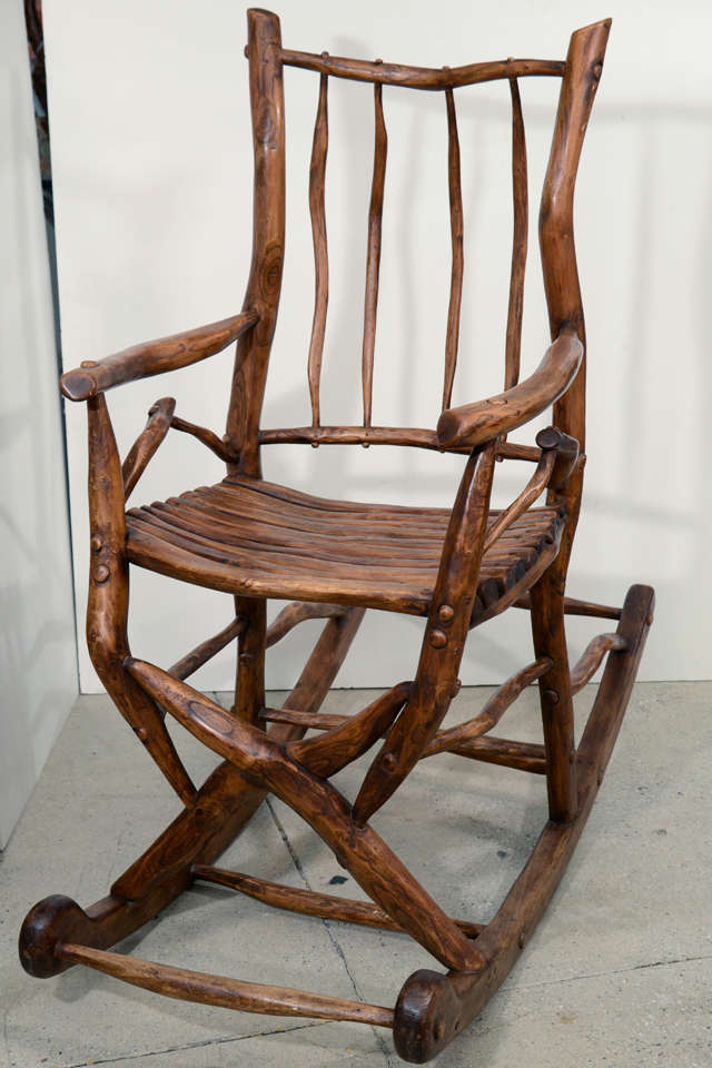 A wonderful sculptural rocking chair assembled from found tree roots and branches from the turn of the century with warm mellowed patina.
All peg construction and all very sturdy.
Monogram signature on the front stretcher.