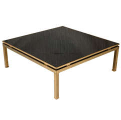 Square gilt brass coffee table with black colored glass top