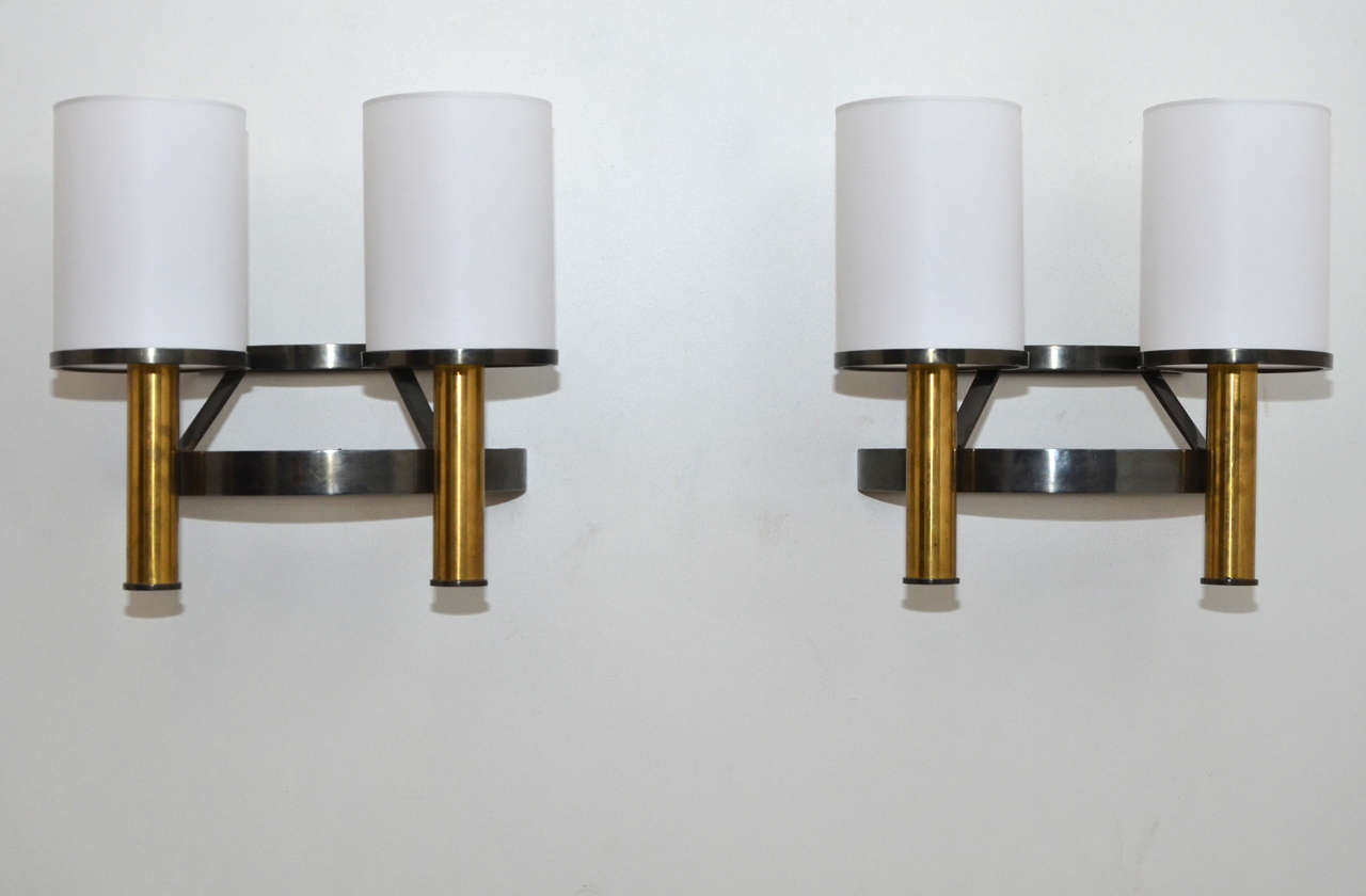 Two 1960s sconces in  dark and gilded patina metal; new shades in a type of plastic called rhodoïd, made to original model. Wired for European use.