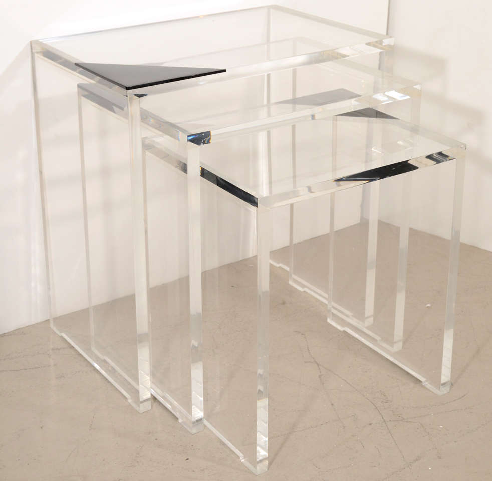 Heavy clear lucite tables, each inlaid with a black triangle at one corner. By Lion in Frost, Ft. Lauderdale.
Largest table: 24