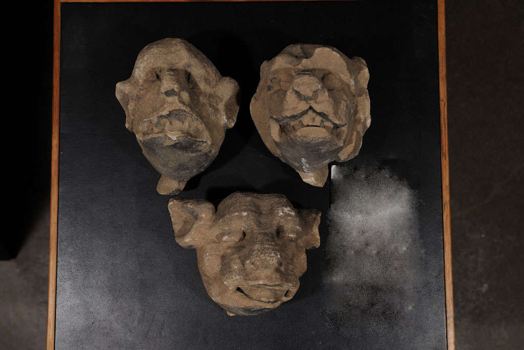 Carved limestone 15th century architectural gargoyle faces-carved in the grotesque manner.