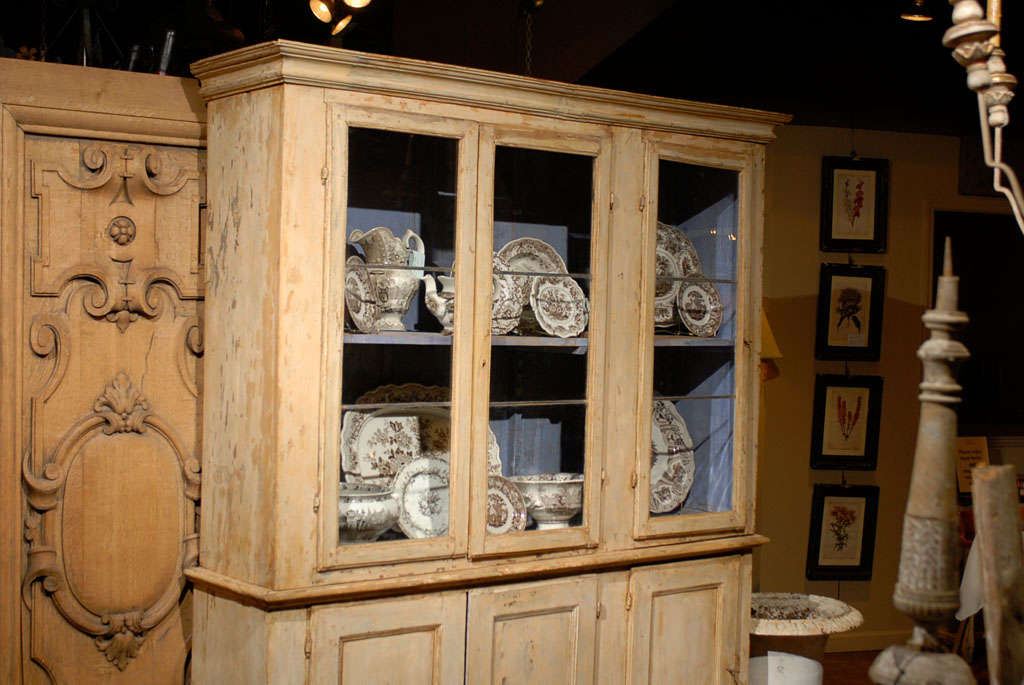 Early 19th century original paint decorated Swedish vitrine, the corniced top surmounting a triple glass paneled door cabinet opening to reveal two shelves above a triple door cabinet opening to reveal two shelves, raised on tapering feet, the doors