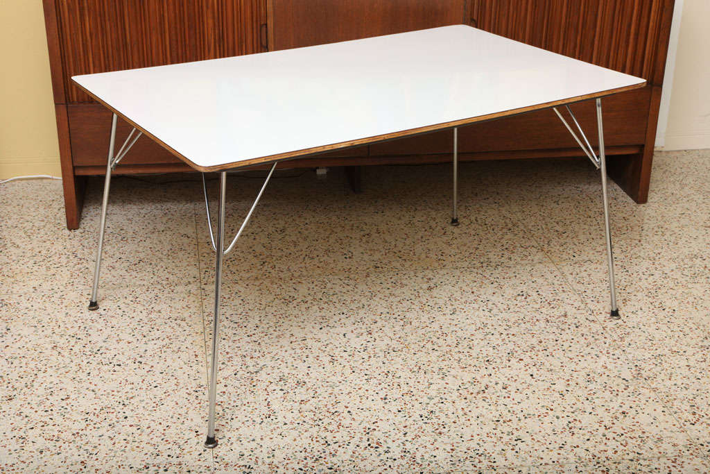 ...SOLD AUGUST 2012...Iconic 1947 design by Charles and Ray Eames, the DTM-10, made by Herman Miller with rectangular white Micarta laminate top over birch plywood and having folding chromed steel legs that lock into place with chrome hairpin