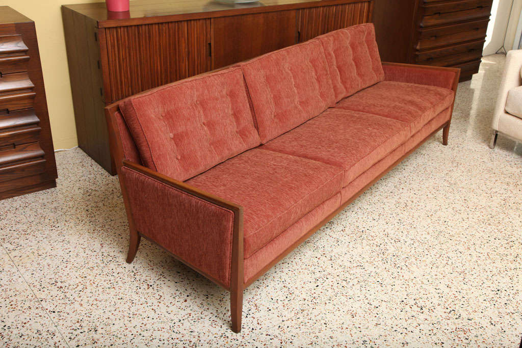 SOLD SOLD Grand & elegant, in the style of Robsjohn-Gibbings, this shaped and softly flared leg walnut mid-century three seater sofa features tufted back cushions along a back that has a hint of a soft curve employed by Robsjohn-Gibbings.  Quite