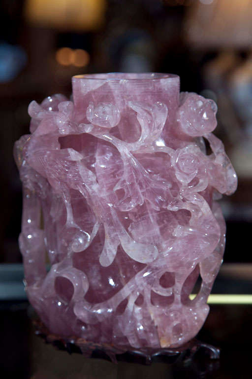 Beautiful Chinese carved rose quartz covered vase, possibly 2nd quarter of 20th century, the cap depicting a phoenix figure, the body of intricate carving of scrolls, flowers, and birds, attached to a wooden carved base.