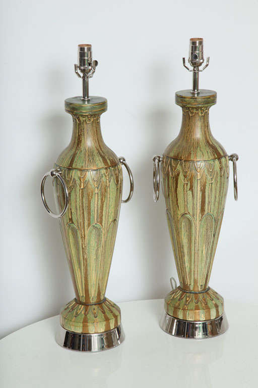 Pair of ceramic lamps in a molten green, gold, and brown glaze featuring chrome hoops and bases. Rewired and appointed with nickel fittings.