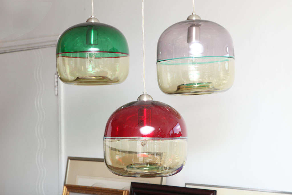 THESE DELIGHTFUL PENDANTS ARE  TRIO OF MURANO HAND MADE GLASS AND STAINLESS STEEL HARDWARE. EACH FIXTURE IS IN A DIFFERENT COLOR COMBINATION , GREEN, RED AND LILAC.