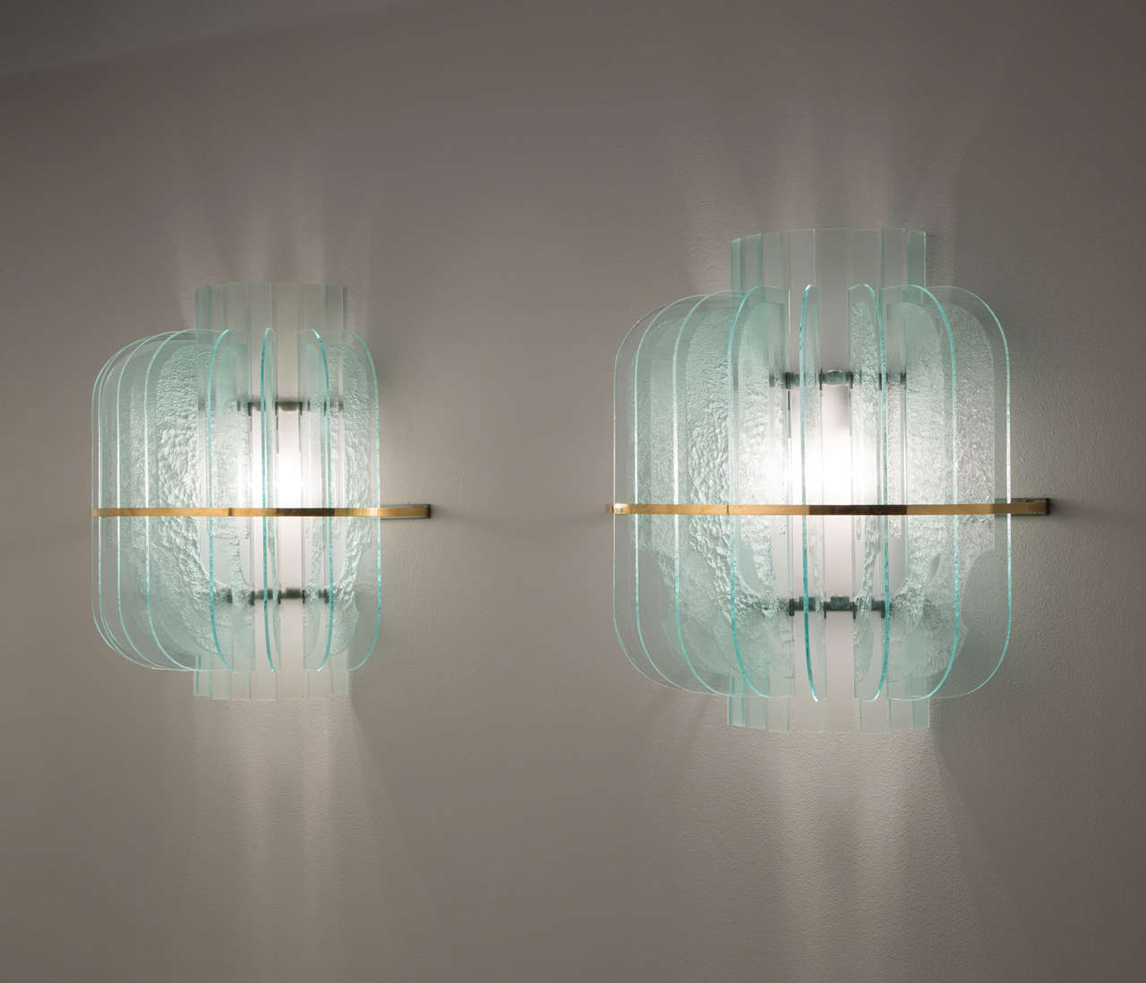 Set of three wall lights, in glass, metal and brass, Italy, 1950s. 

Set of five large wall lights in structured glass and brass details. These lights are designed in the manner of Fontana Arte. A halve round design featuring nine structured and