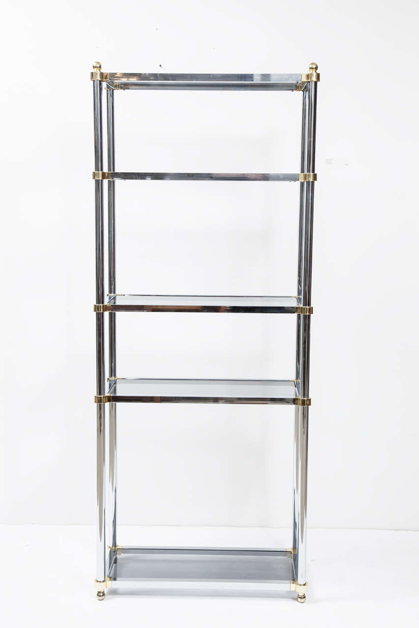 A pair of high quality, nice looking étagères in brass and chrome attributed to Milo Baughman for Design Institute of America. There are five shelves of tinted glass. The rounded corners on each shelf are a unique feature, and set this pair apart
