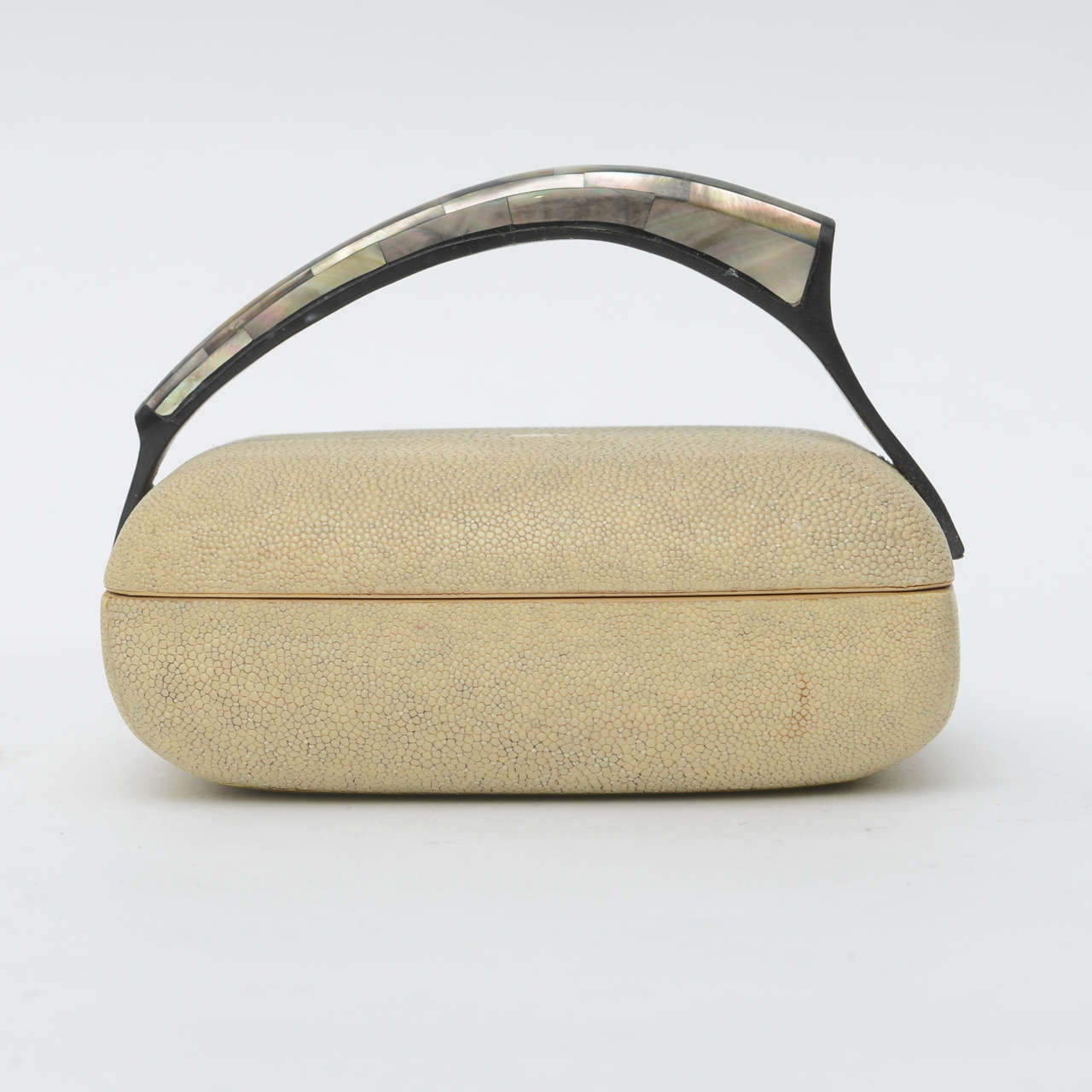 The mother-of-pearl covered handle over a lidded box in shagreen, marked R and Y Augousti on bottom.