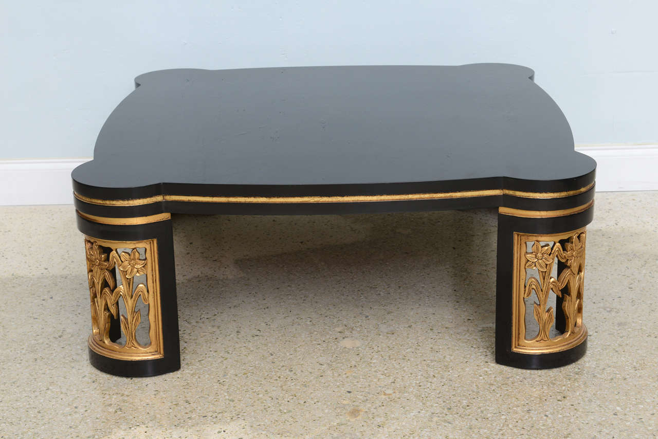 The top with rounded edges in black lacquer with rounded legs in floral motif with parcel-gilt.