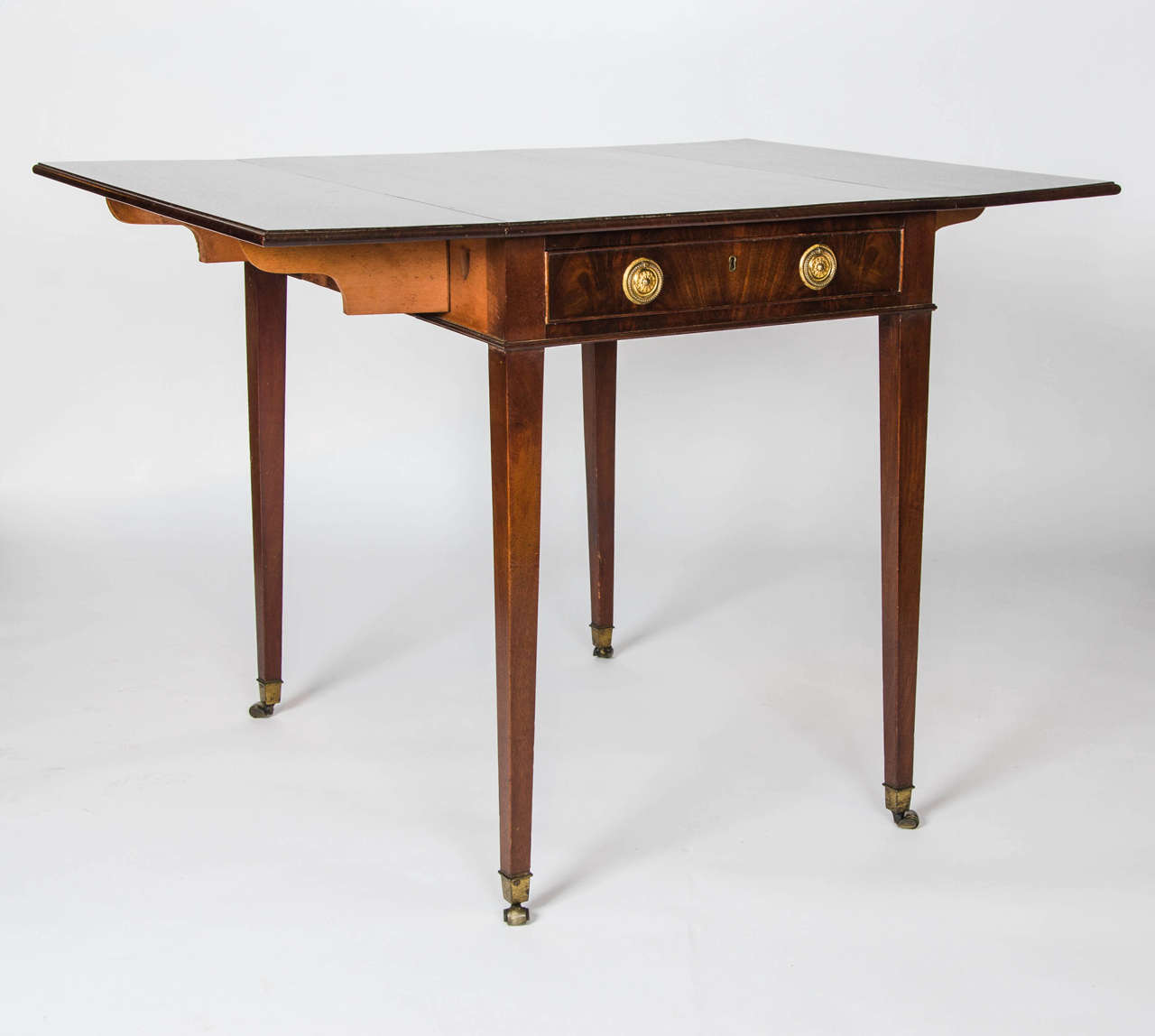 A fine George III period mahogany Pembroke table with single ling drawer, original handles standing on square tapering legs terminating in the original cap barrel castors.