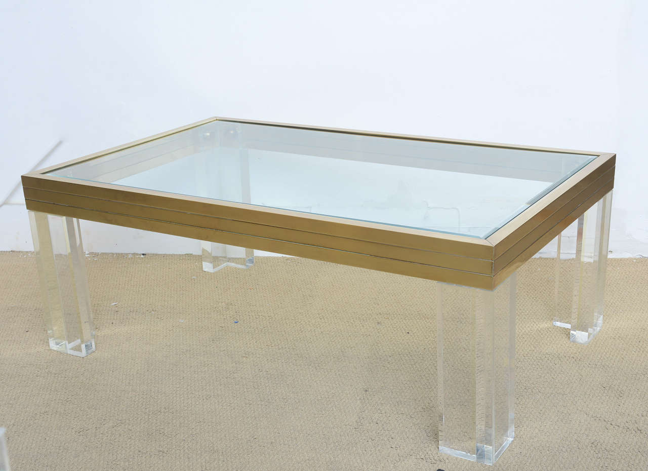 Chic Minimalist coffee table by Romeo Rega designed in Italy in the late 1970s. An amazing use of materials, solid brass frame and thick Lucite legs floating a glass top. A great piece to add to your interior.