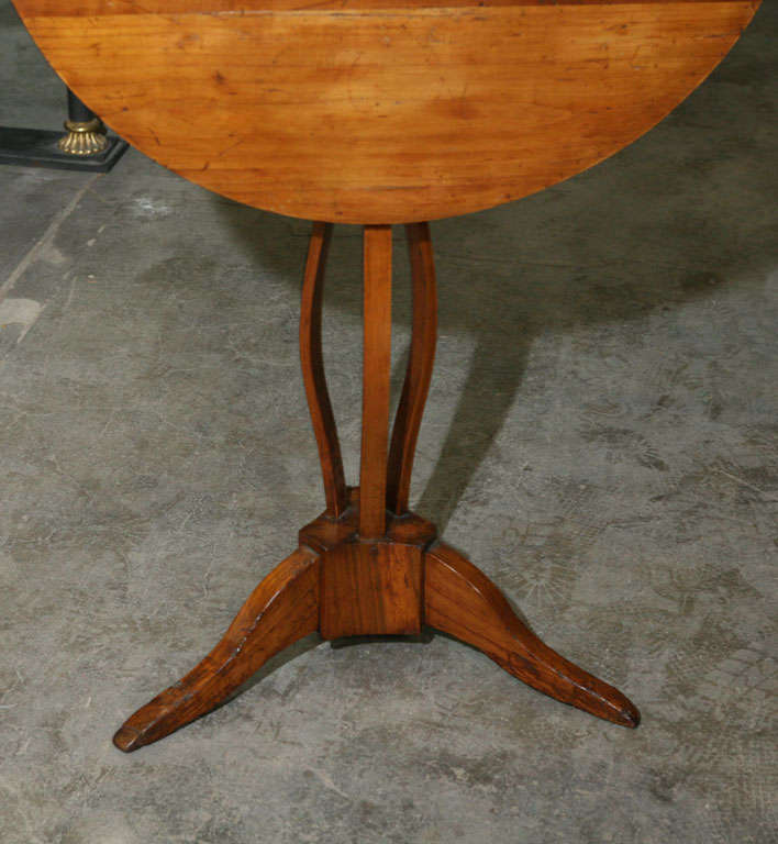 This lovely tilt top table is a great example of the refinement used in country furniture during the early part of the 19th century. Made of fruitwood the table has a great warm color and a simple yet highly complicated form.  The usual support