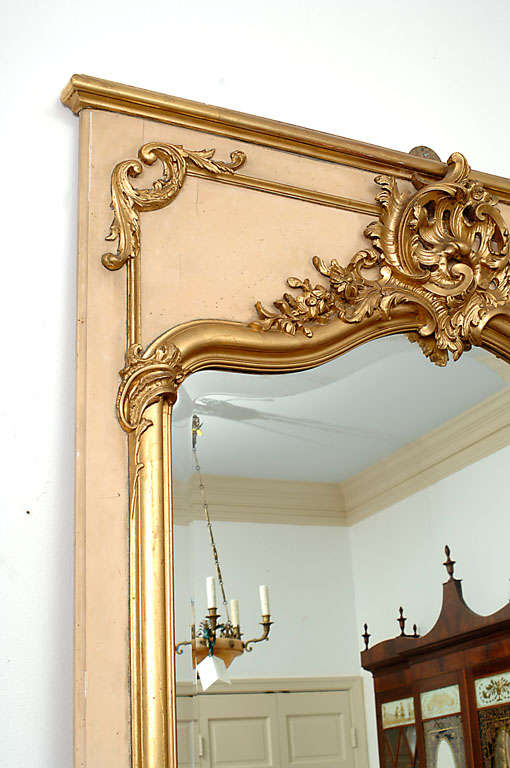This Rococco style mirror is an excellent hand-carved copy of an 18th Century original. The beveled glass adds a nice touch to the overall appeal of the Trumeau.  $2,900.