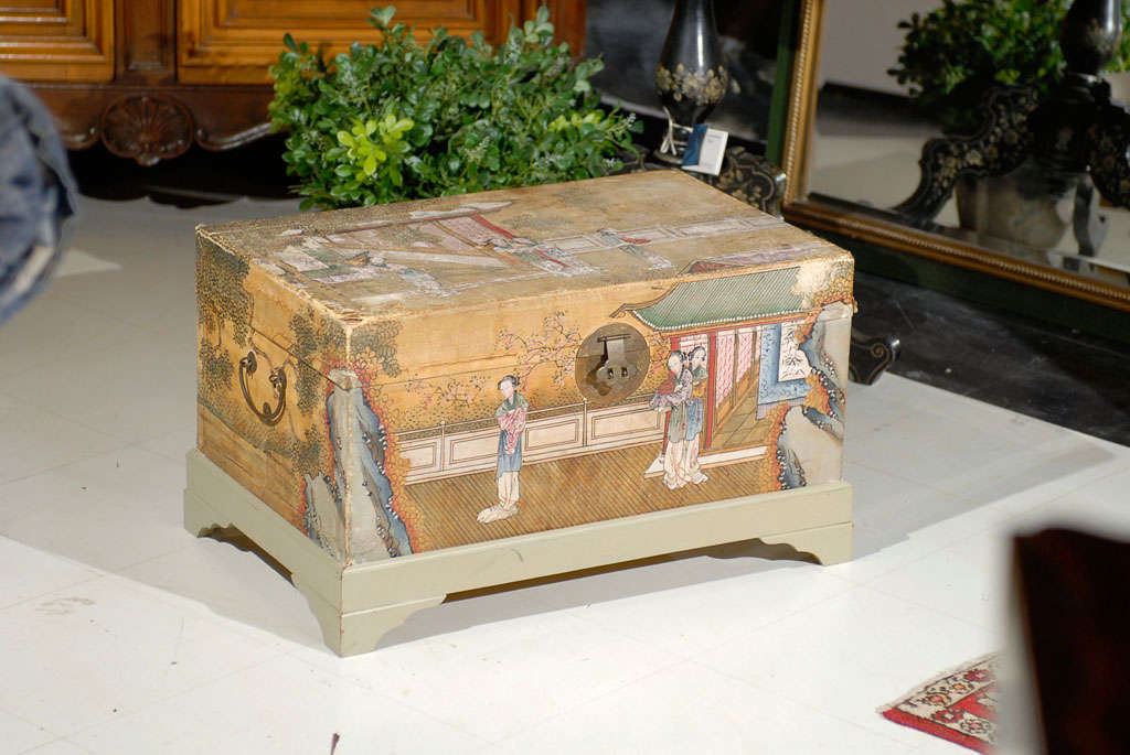Chinese pigskin trunk with polychrome painting of ladies in a garden with pavilions in the background. Custom tufted vibrant upholstery in the interior.  Raised on later custom painted stand.
