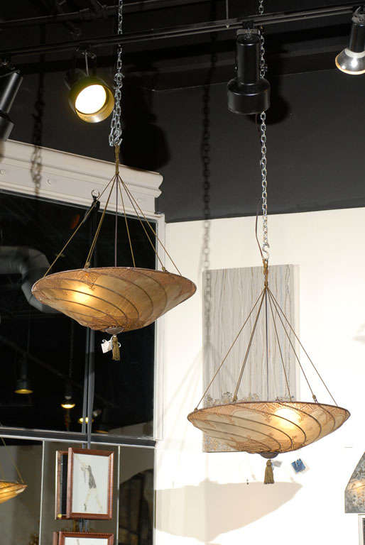 Decorative pair of Moroccan hanging lanterns of hand painted parchment over wire frames.  20th Century made in the style of Fortuny.