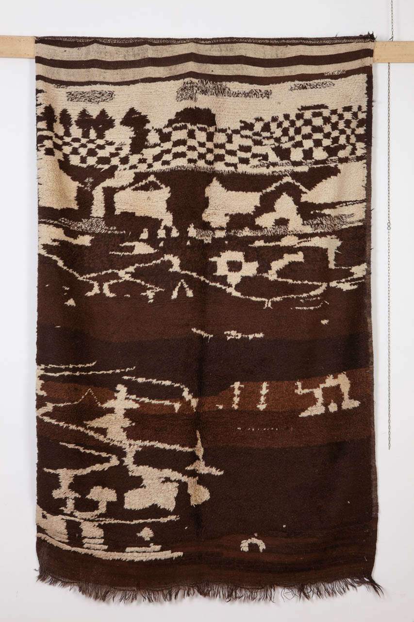 Originating from the Rehamna region, located in the plains of Marrakesh, this rare and unusual carpet is distinguished by an abstract pattern executed in the tones of dark brown and ivory wool, which is natural and undyed. 
A unique carpet which