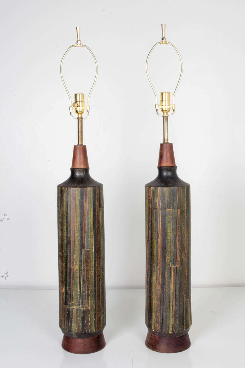 A pair of ceramic lamps with a textured graphic pattern. Having teak accents and brass fittings. Designed for Raymor by Aldo Londi for the Italian maker Bitossi.

Dimensions:
Overall: 40-1/2