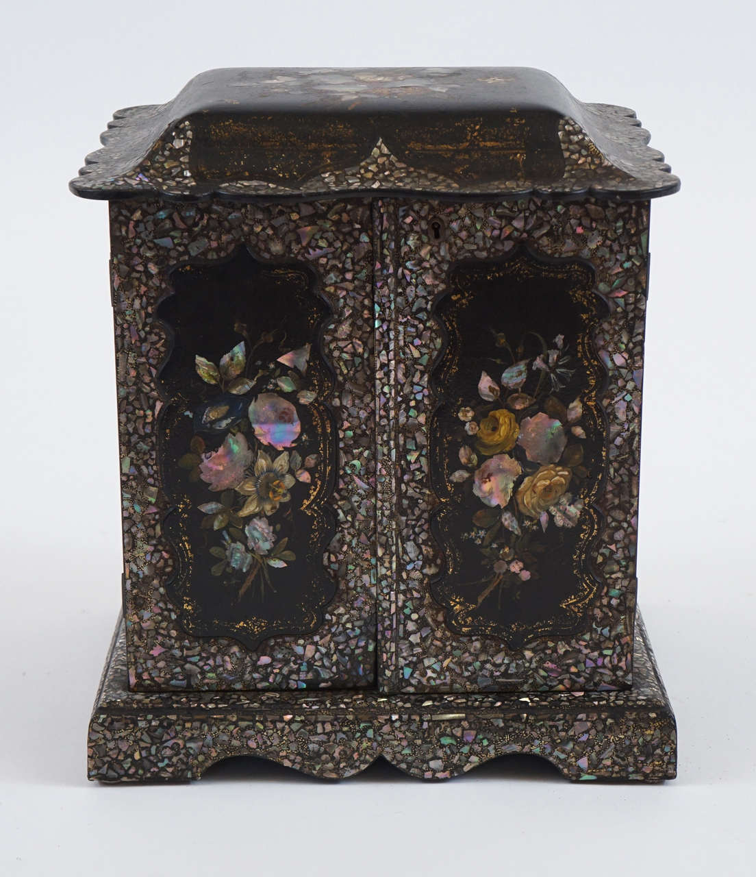 Exquisite English papier mâché table cabinet having all-over inlaid mosaic abalone (mother-of-pearl) and floral designs with painted and gilt motifs. Interior with velvet lined top compartment and six drawers with carved mother-of-pearl