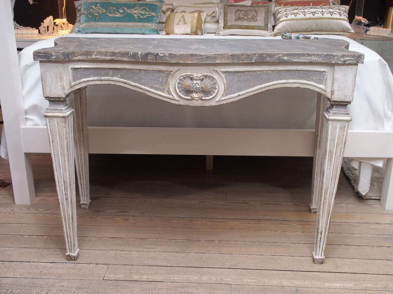 This pair of painted, wooden Italian console tables have square tapered legs that are typical of a 19th century Louis XVI period piece.  The top is painted and faux finished to look like grey marble with natural looking patches of brown, off white