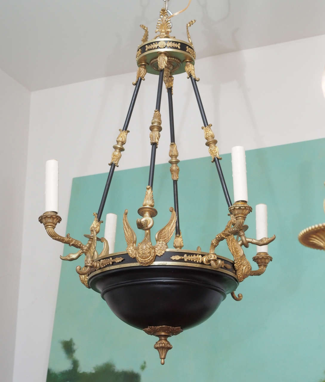 This exquisite French Empire chandelier has wings of golden, lacquered bronze that sit atop black cast metal.