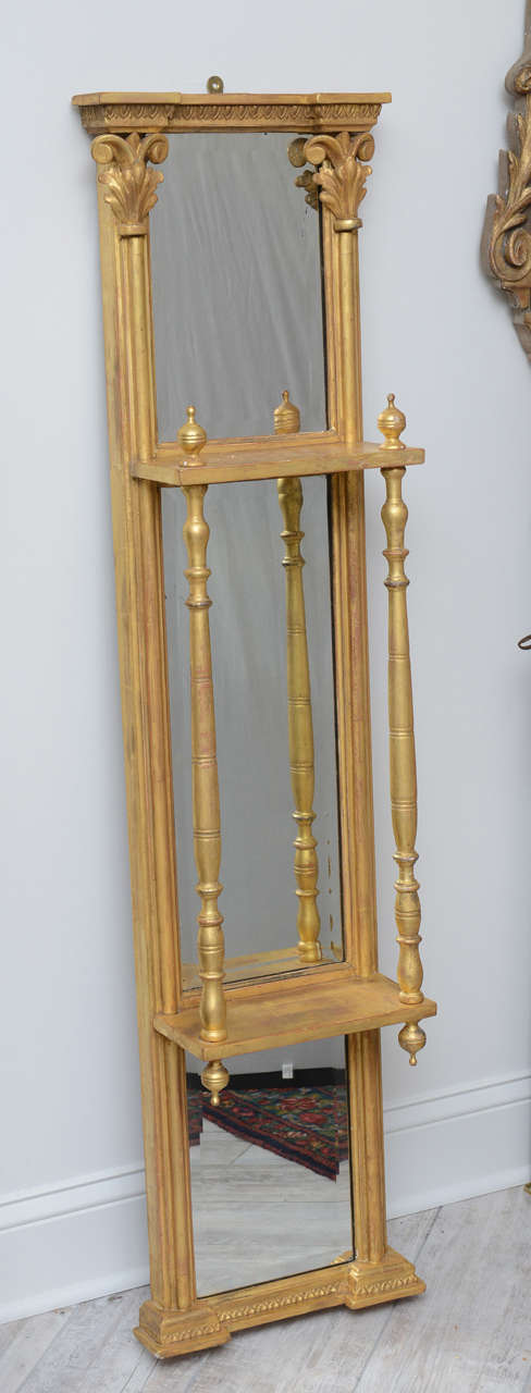 Elegant pair of gilded mirrored wall hangings with two shelves and beautifully carved column details.