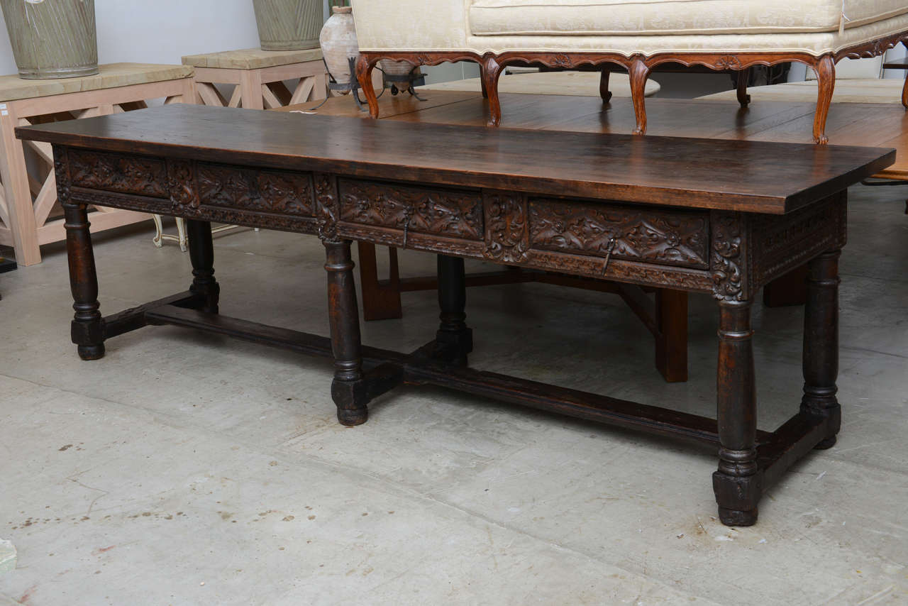 17th or 18th century stretcher base with later antique top. Four heavily carved drawers on front and beautiful carved back.