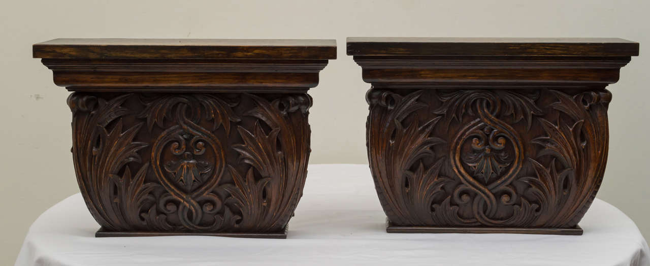 Pair of late 19th century American oak wall brackets composed from antique architectural elements. Solid high relief carved foliage on front and sides. Dark finish and reverse side with two brass hangers. There is a .25 inch difference in size due