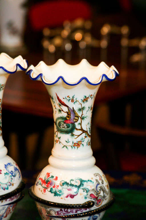 Pair of flamboyant French opaline vases in baluster form with frilled edges outlined in cobalt blue, painted with decorations of birds and birds' nests, flowers and leaves, the body of each vase encircled by a cobalt blue and gilt snake.