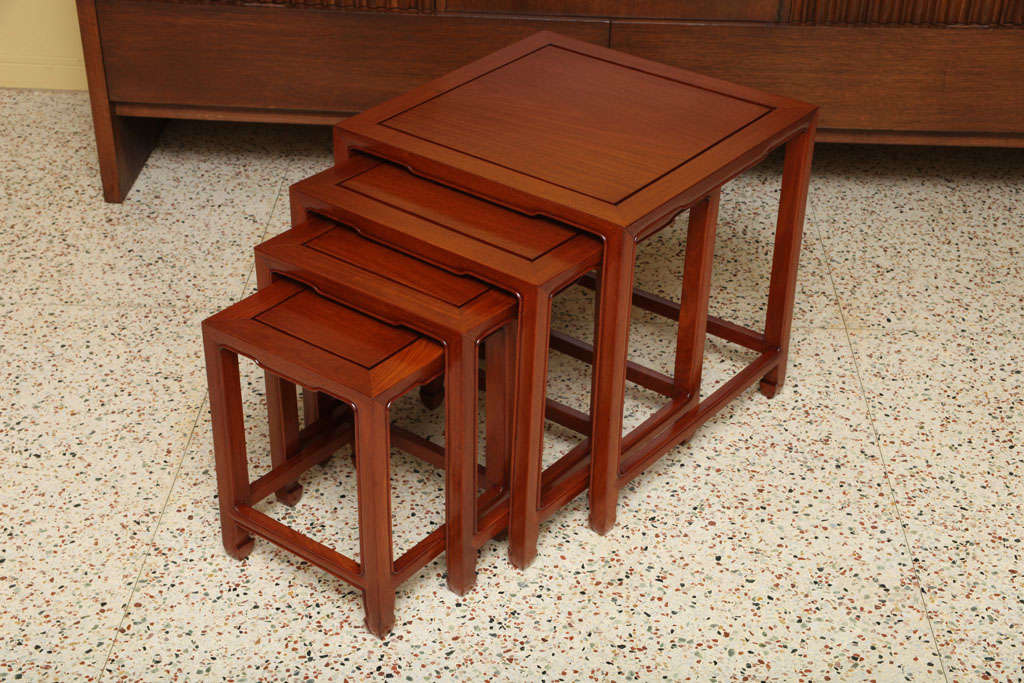 Reduced from $2450. This richly appointed set of tables is in the style and quality of Baker's Far East Collection. In solid carved teak with a lustrous finish, this set of four nesting / stacking tables feature a sculpted beautifully carved, shaped