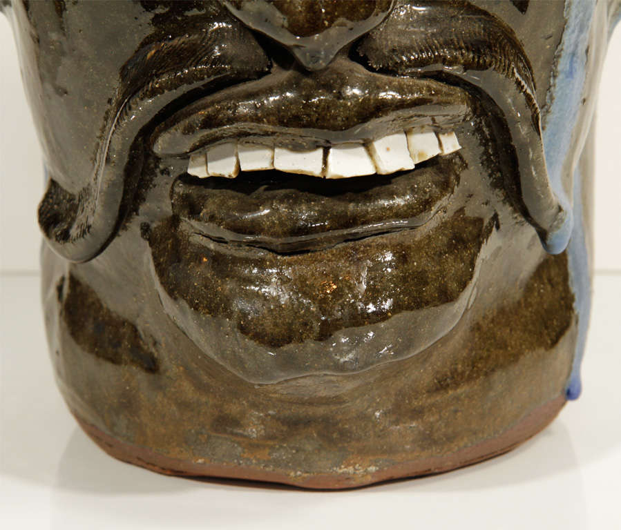 Extraordinary example alkaline glazed face jug by renowned folk artist Chester Hewell features fantastic details in the teeth, mustache and nose. Initialed on the handle and signed and dated on the bottom.