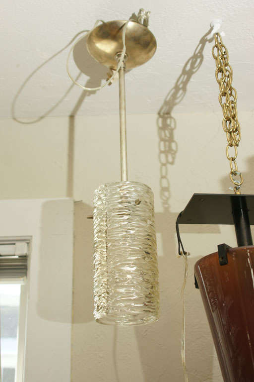 Cylindrical textured glass pendant ceiling fixture with brass details by Kalmar.