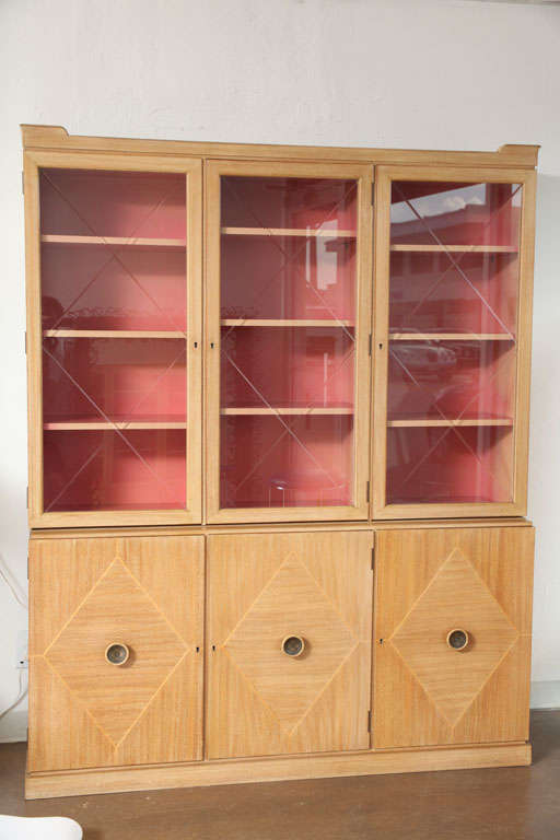 Bleached Mahogany two-piece cabinet, the top section has three diamond etched doors with nine interior shelves in a vivid honeysuckle pink hue, the bottom has three doors and bears the same inlaid diamond pattern as the glass, same interior color