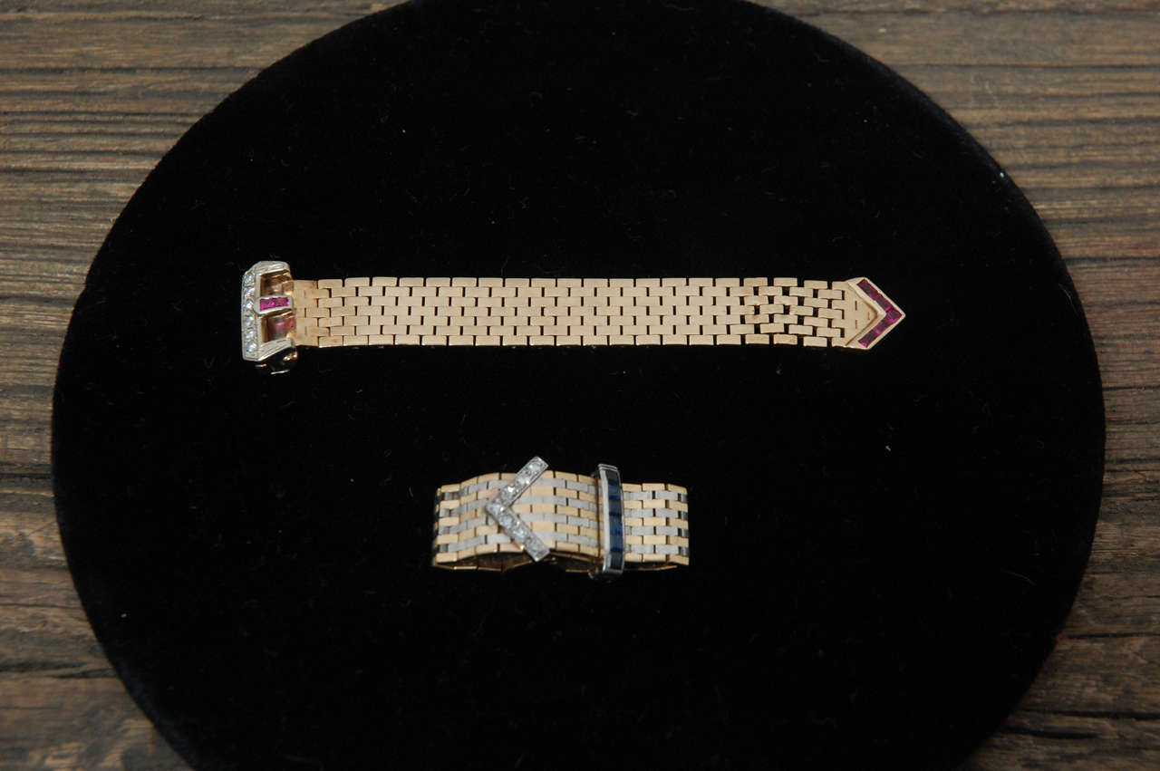 Two retro buckle rings one with rubies and diamonds, and the other with sapphires and diamonds.  The sapphire ring has been
soldered closed, but that can easily be undone. As is the  size is about 6 or 61/2.  Sold separately.  The rings are 3.25