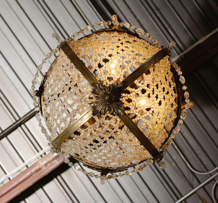 Impressive and unusual 19th century crystal and bronze chandelier purchased in Vienna. There are four lights on the outside, two inside the basket and one under the crown. 