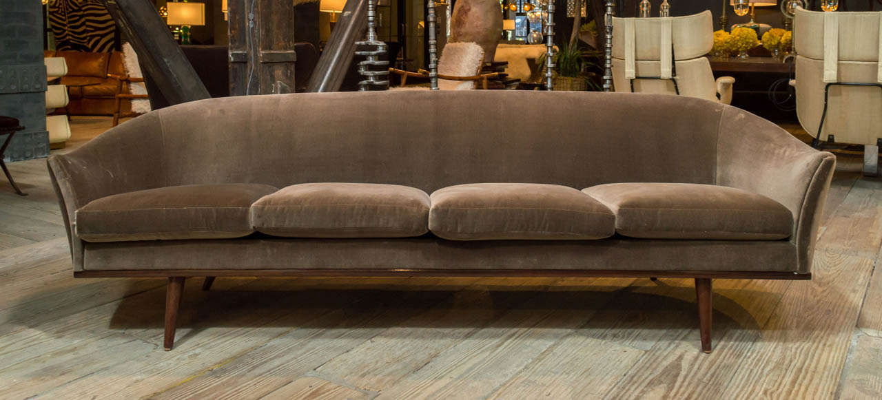 A four seat sofa attributed to Ico Parisi. Features a beautiful arched silhouette with Newly reupholstered in a beautiful mocha colored velvet. Tapered walnut legs.