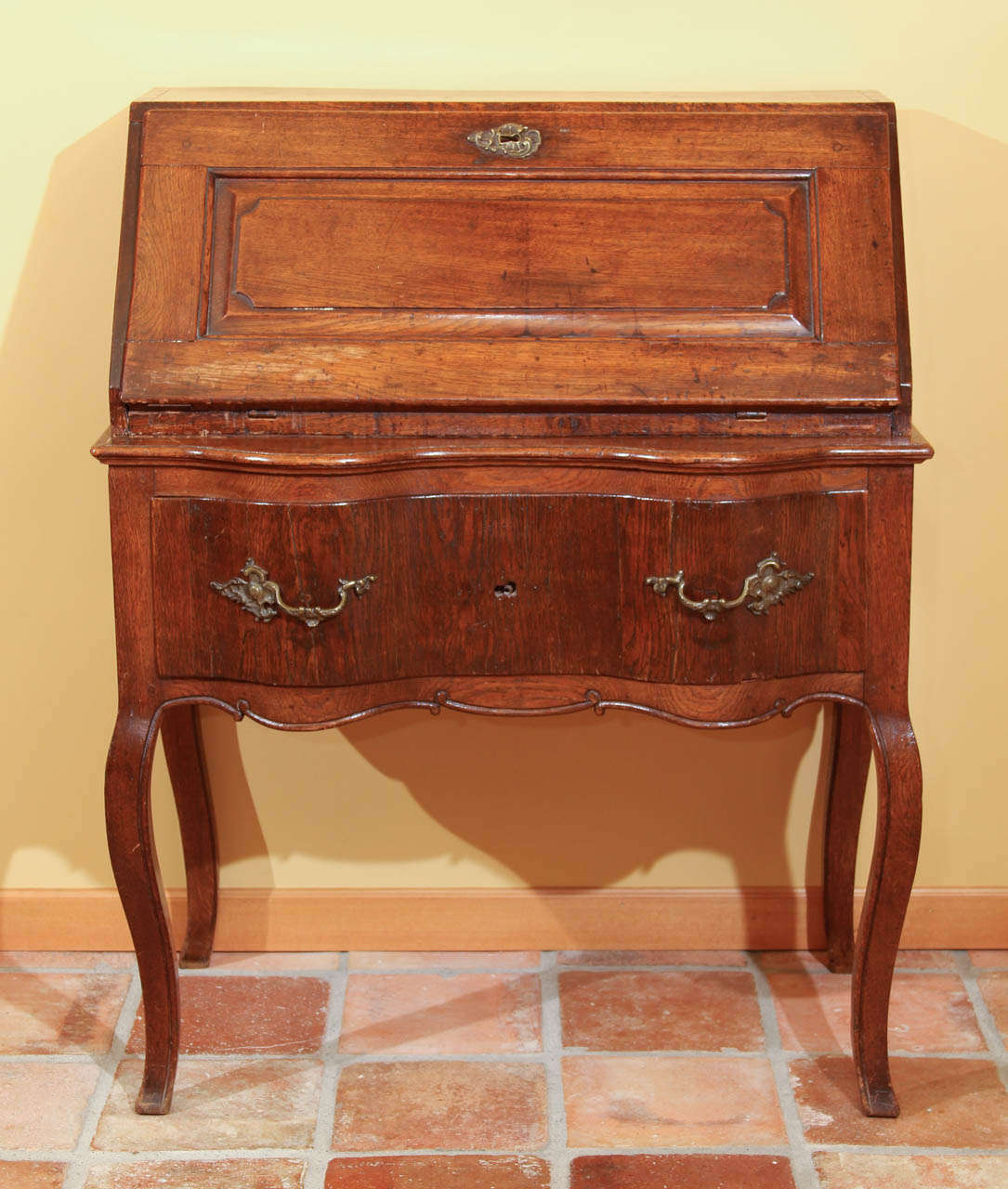 Dutch 18th Century Drop Front Desk

This is a very early, Dutch oak desk with a drop down front. The front slat lid has raised panel work and a beautiful old Louis XV escutcheon. Behind the escutcheon is the old lock (no key).

The interior