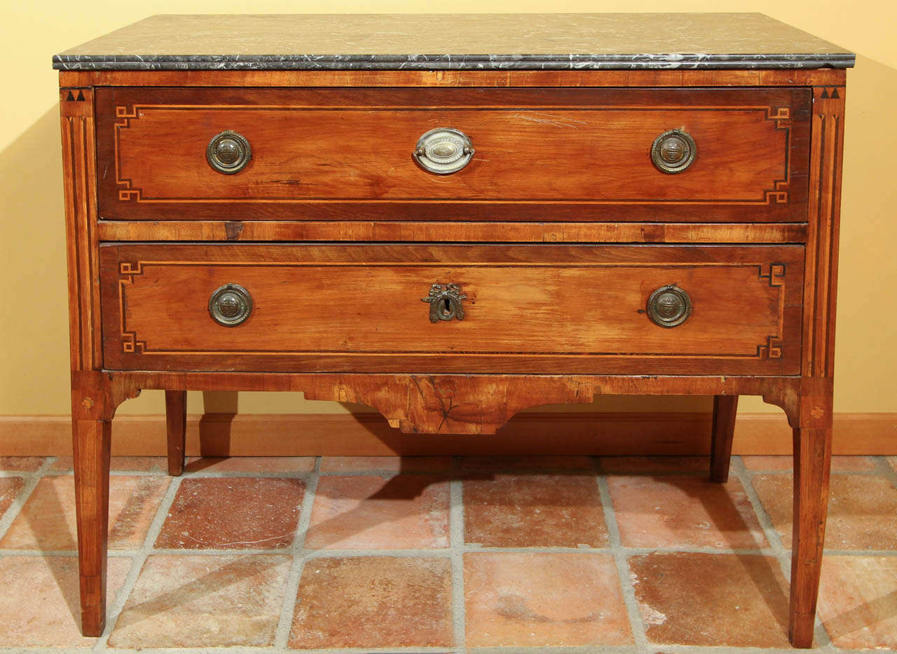 French Louis XVI Two Drawer Commode

This is a handsome two drawer chest that features four tall tapered legs.  

The mahogany veneer work on this commode has a lot of intricate string inlay design on both the front or the drawers, on the side