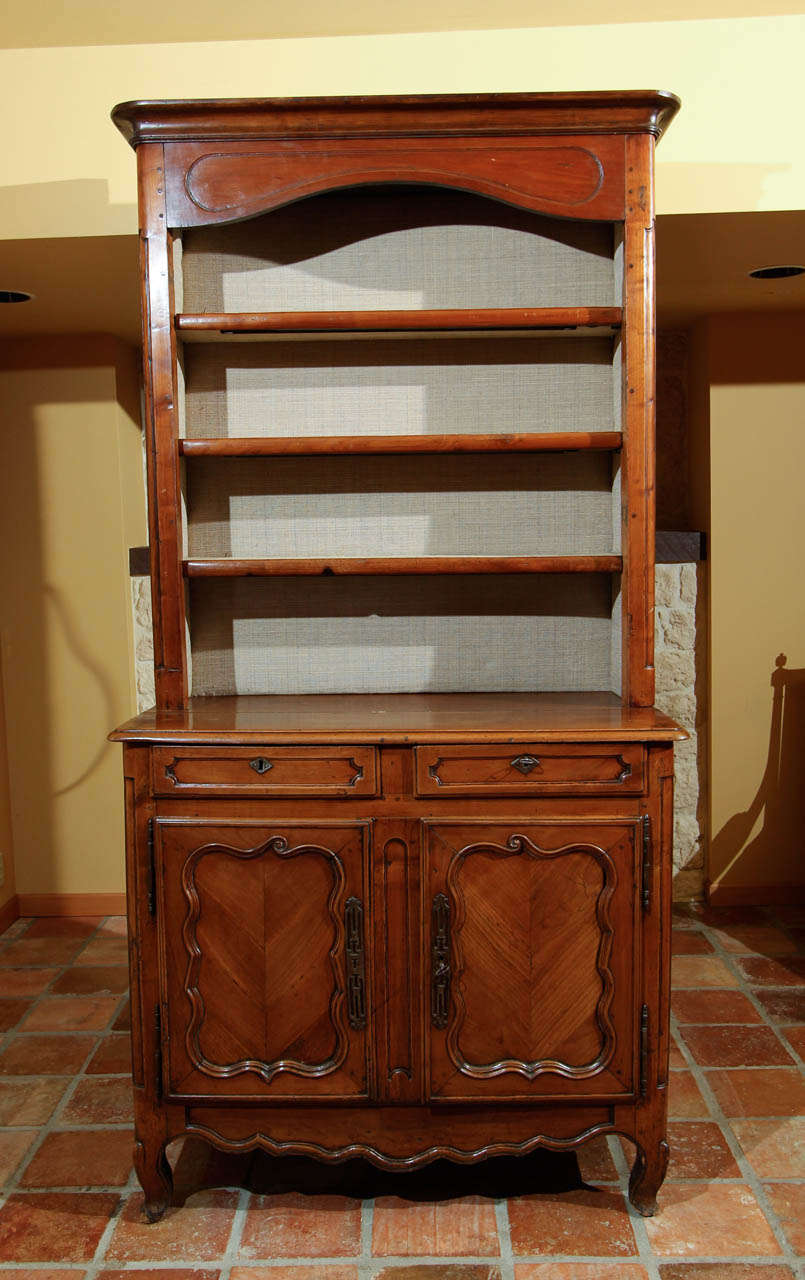 French Louis XVI Cherry Vassellier or Dresser

This is a wonderful petite French dresser with a buffet on the bottom and an open plate rack on the top.

The top has three shelves with the a simple carved frieze across the top. Each shelf is