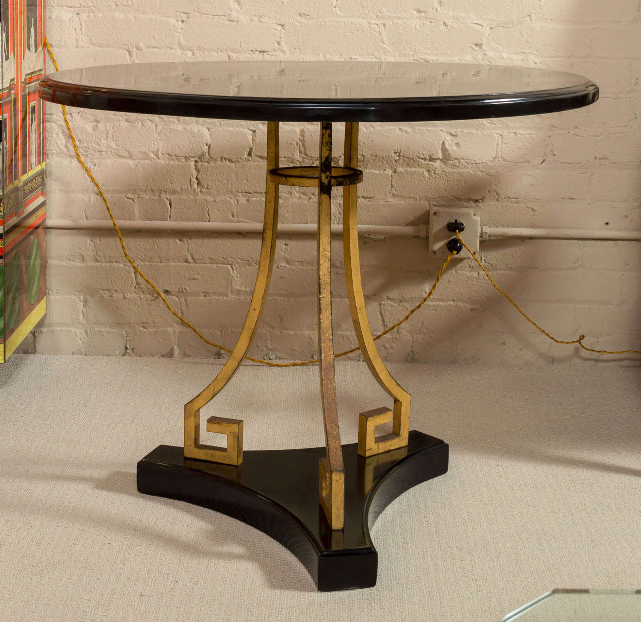A Neoclassical table with an interesting, gilded, wrought-iron base and black-lacquered wooden top.
Marked - France - under top