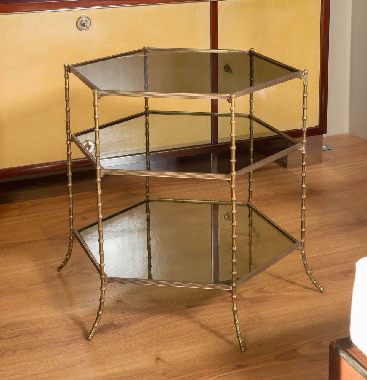 A chic, bamboo-motif, hexagonal, side-table in patinated bronze with three tiers of smoked glass.
France - circa 1960