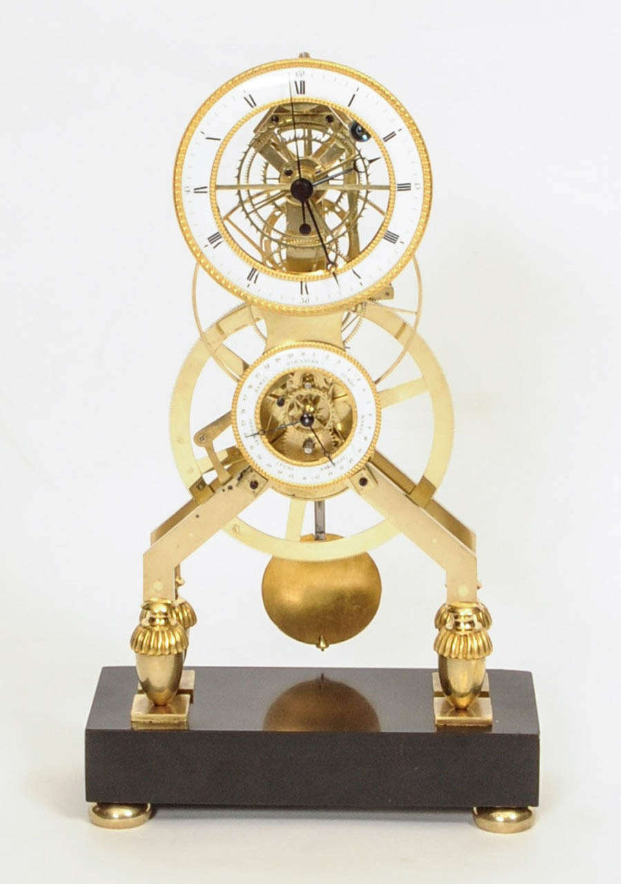 A Rare French Directoire Ormolu-Mounted Brass and Black Marble Skeleton Mantel Clock circa 1795. A complicated skeleton clock with remontoire, central sweep second and an extra dial indicating day and date. A rare complication is the so-called jump