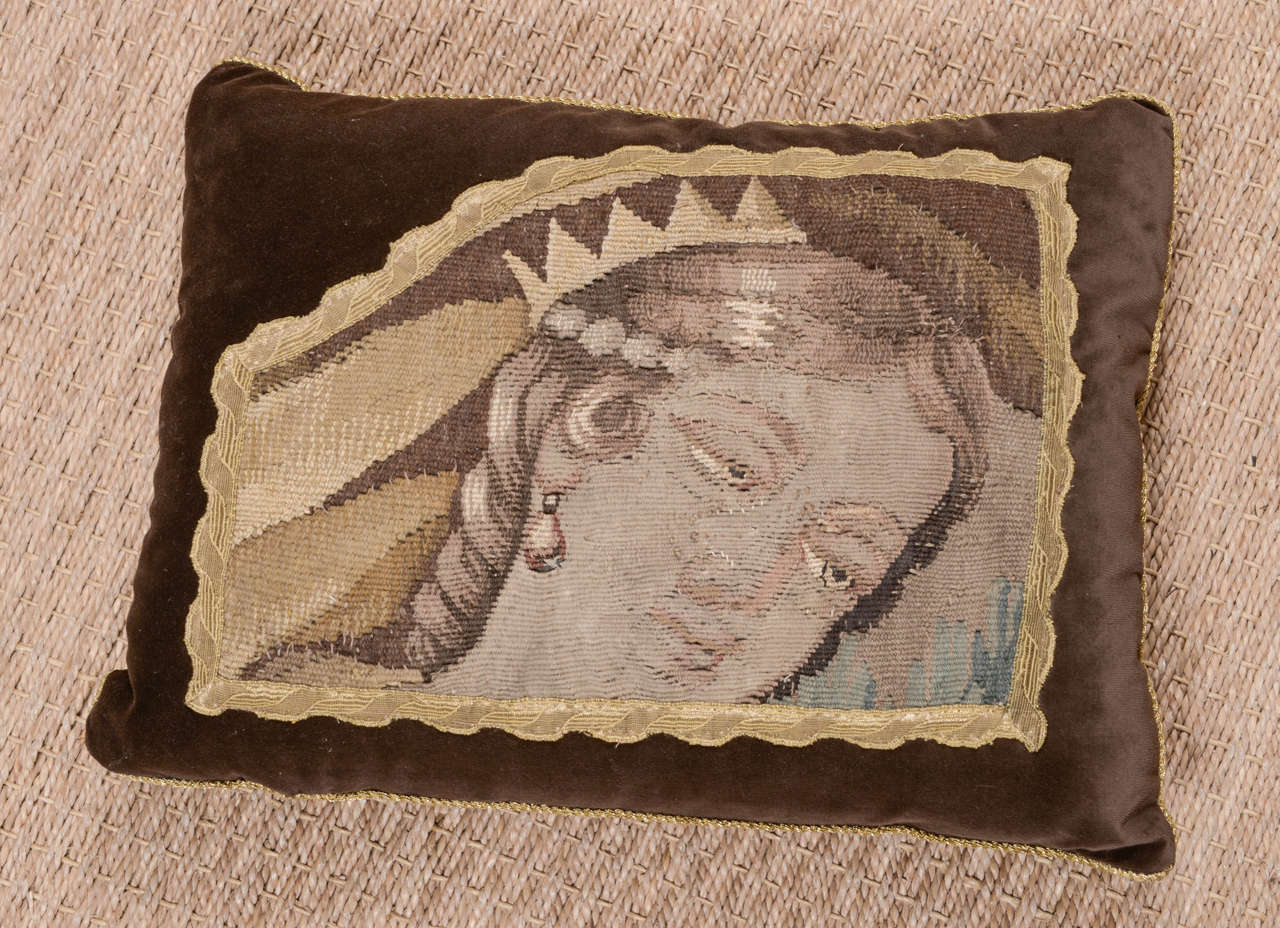 16th century tapestry fragment pillow featuring Italian figure. Pillow is constructed with 100% cotton velvet in rich chocolate hue and finished with gold braid along edge. Tapestry is bordered with antique metallic gallon of scalloped design. Down