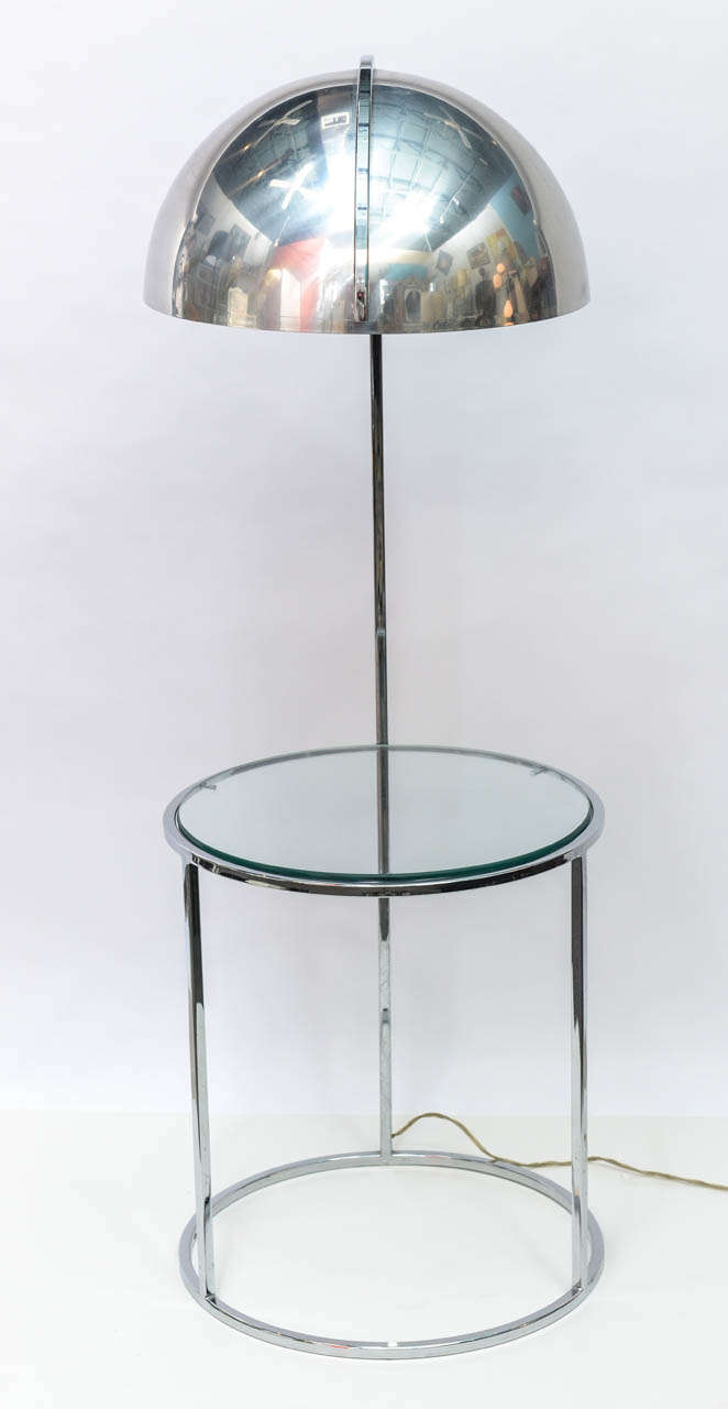 Add a distinctly modern and dual purpose piece to your sitting area. In one swift move, you have light to read by and a place for your snacks.  Ta da! A wide, lit chrome dome stands stylishly above a circular chrome and glass table. 
Lamp underside