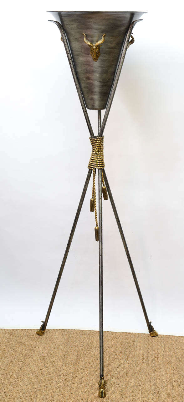 Striking pair of steel and brass metal planters. Top of planters have rams head surrounds. Base has brass cord and tassels tied in the middle and finishes with hoof feet at the base.