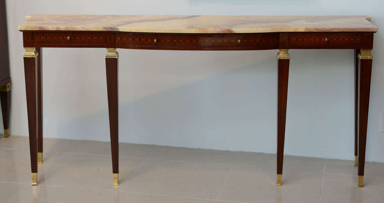 The onxy top over a frieze inlaid in geometric form with four drawers, over square tapering legs headed with bronze mounts and terminating in sabots, Paolo Buffa.