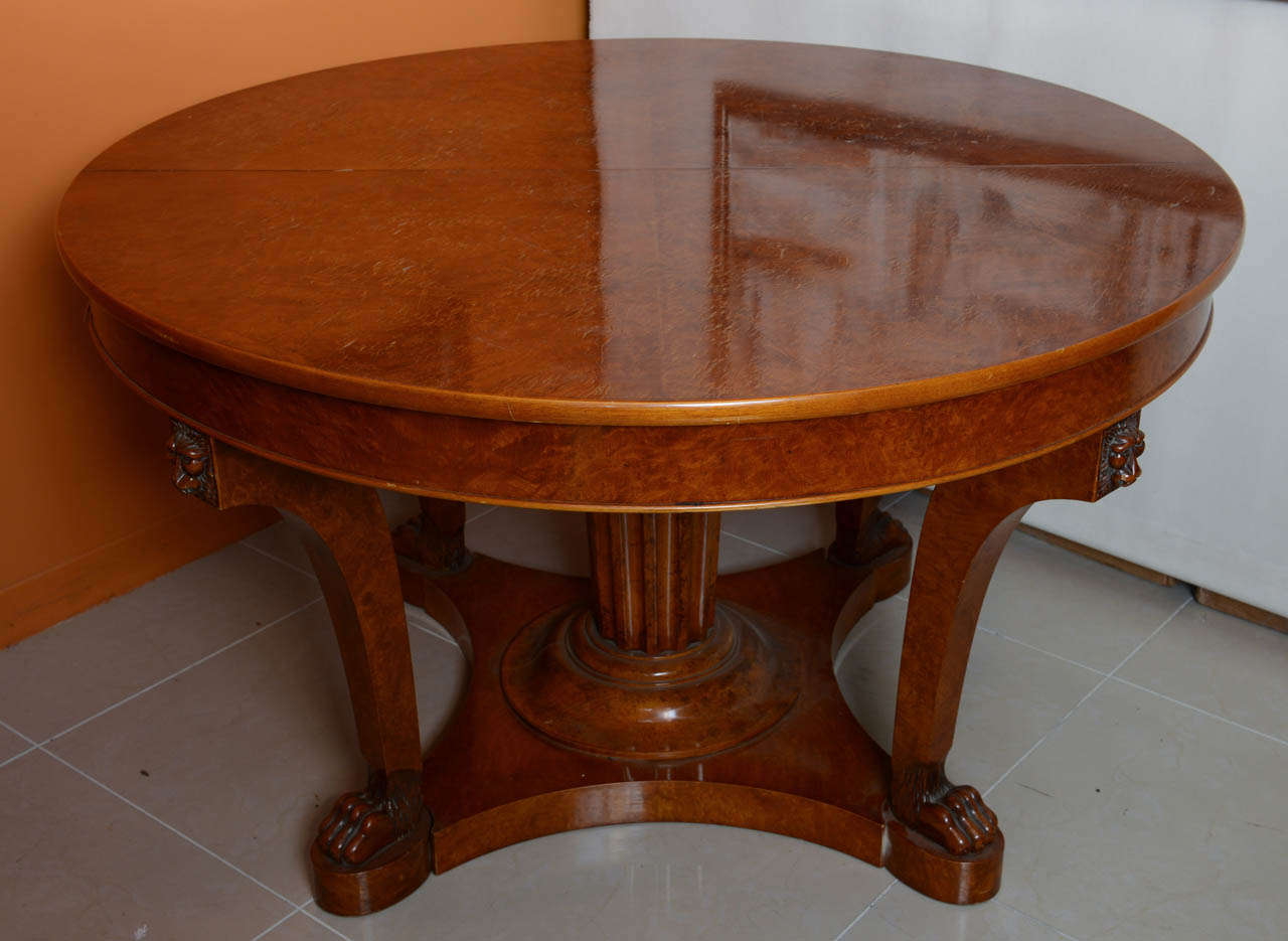 The circular top over curved tapering legs headed with carved lions faces and terminating in lion paw feet, with a central fluted column all on a plinth, separating to accept four original leaves to create a masterful dining table.
Leaf is 21