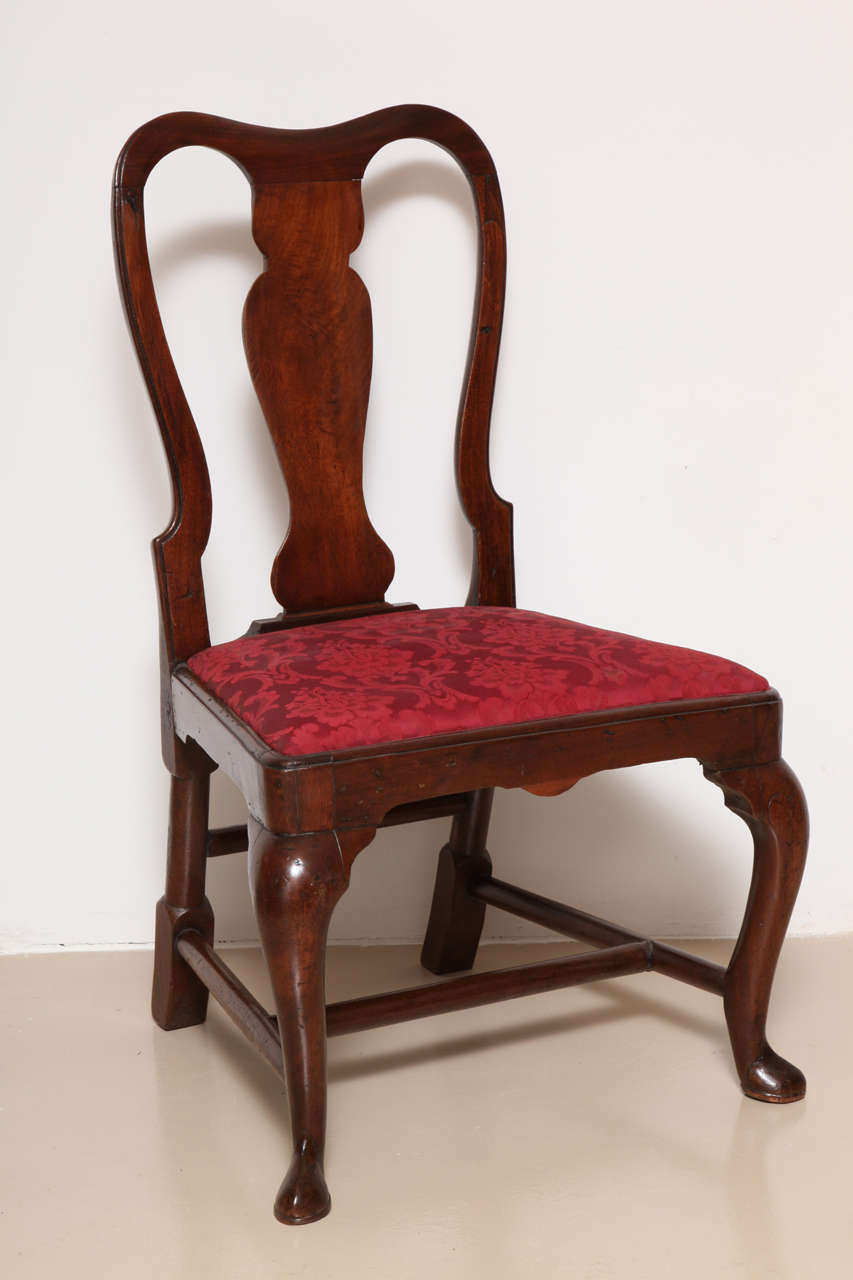 The tall back centered by a solid vasiform back plat, with drop-in upholstered seat over cabriole legs joined by stretchers and terminating in later feet.