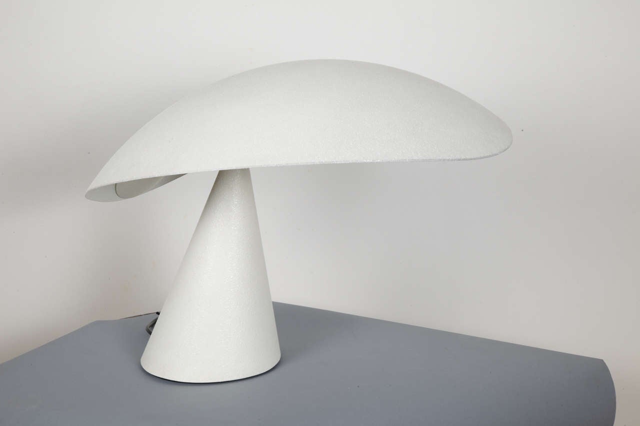 Elegant white lacquered metal Lavinia table lamp by M.Kurosawa, designer and architect, created in 1965. Edited by Artemide.
Shape as a mushroom, with slightly see-sawing oval hat, on a conical base. Switch and Artemide signature on the base